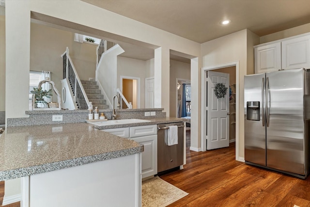 kitchen with white cabinetry, sink, dark hardwood / wood-style flooring, kitchen peninsula, and stainless steel appliances