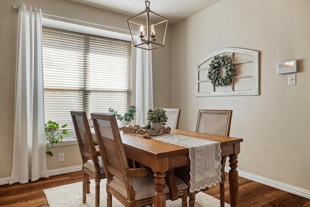 dining area with an inviting chandelier and dark hardwood / wood-style flooring