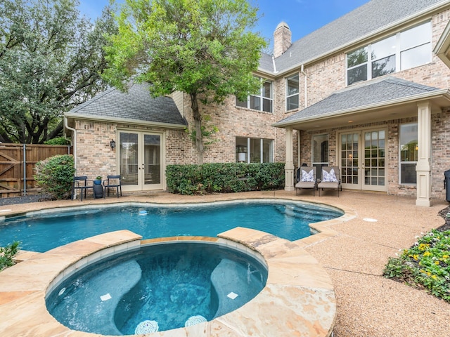 view of swimming pool featuring an in ground hot tub, a patio area, and french doors