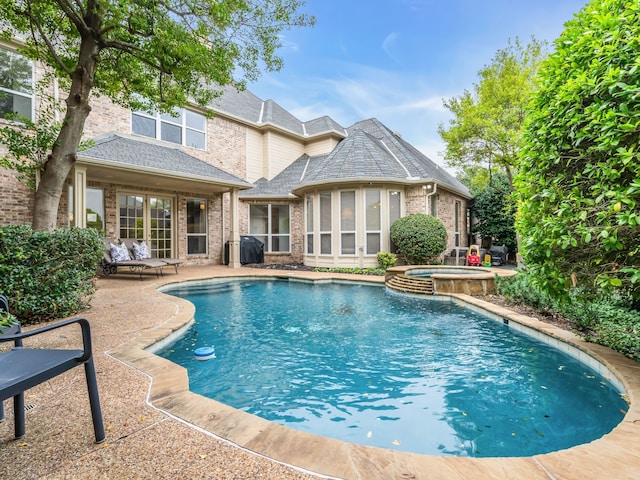 view of pool with an in ground hot tub and a patio