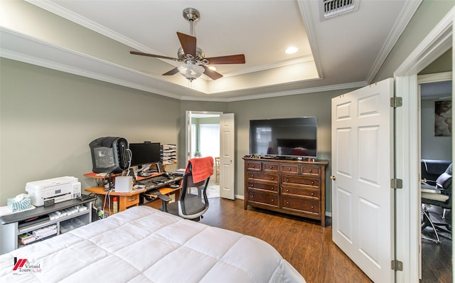 bedroom featuring dark wood-type flooring, ceiling fan, a tray ceiling, and crown molding