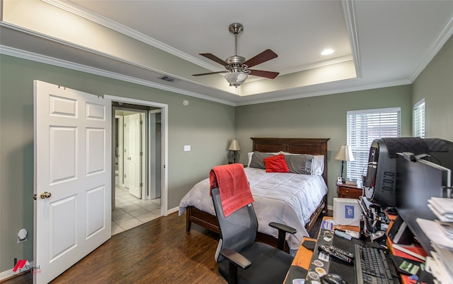 bedroom with dark hardwood / wood-style floors, ceiling fan, a tray ceiling, and crown molding