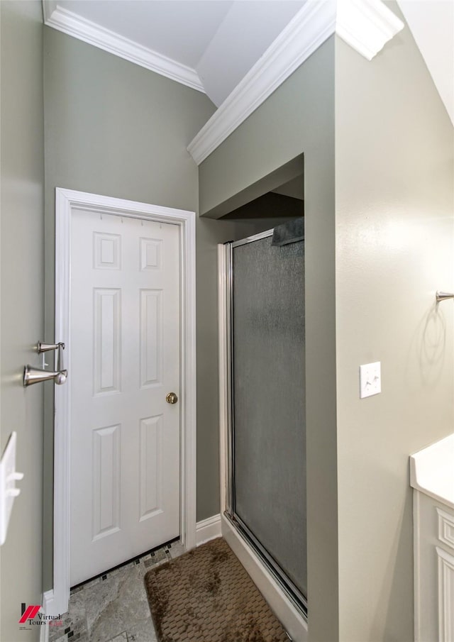 bathroom with crown molding, lofted ceiling, and a shower with shower door