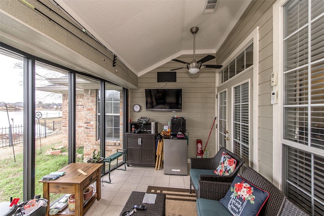 sunroom featuring lofted ceiling, plenty of natural light, ceiling fan, and a water view