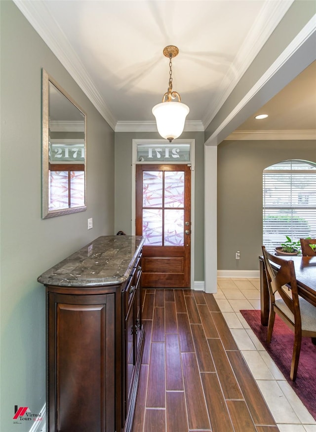 doorway with hardwood / wood-style flooring and crown molding