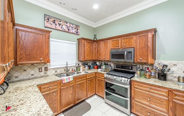 kitchen with sink, ornamental molding, light tile patterned floors, light stone counters, and stainless steel appliances