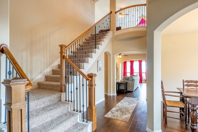 staircase with hardwood / wood-style flooring and a towering ceiling