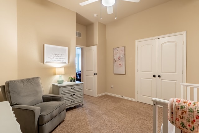 sitting room with ceiling fan and light colored carpet