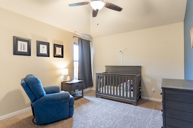 carpeted bedroom with vaulted ceiling, a nursery area, and ceiling fan