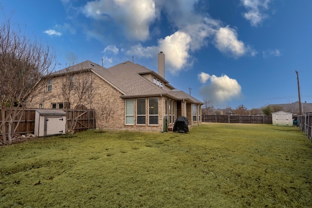 back of property with a storage shed and a lawn