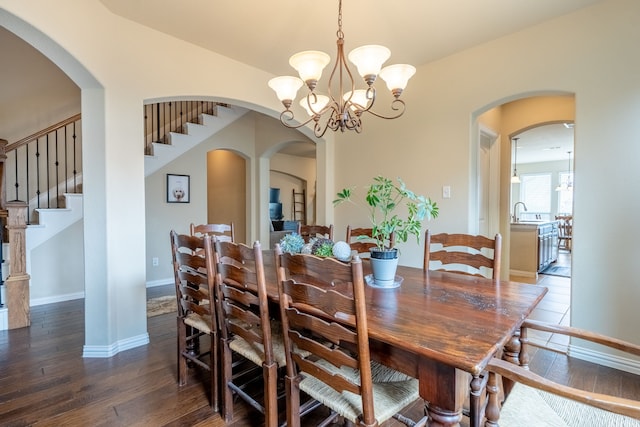 dining space with an inviting chandelier, dark hardwood / wood-style floors, and sink