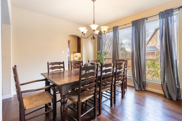 dining room featuring an inviting chandelier and dark wood-type flooring