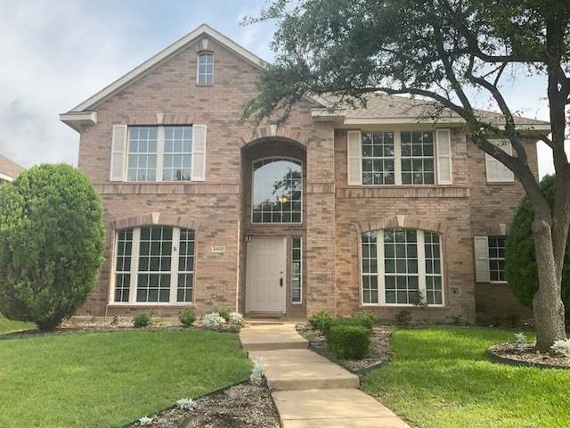 2425 Brycewood Ln, Plano, TX 75025 - traditional-style house featuring brick siding and a front lawn