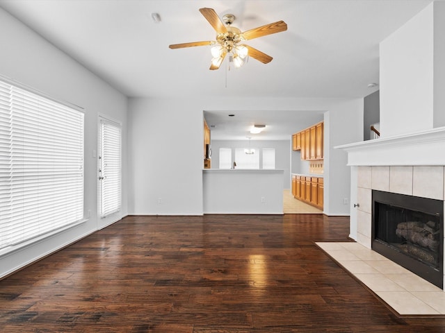 2425 Brycewood Ln, Plano, TX 75025 - unfurnished living room featuring a ceiling fan, a tiled fireplace, and wood finished floors