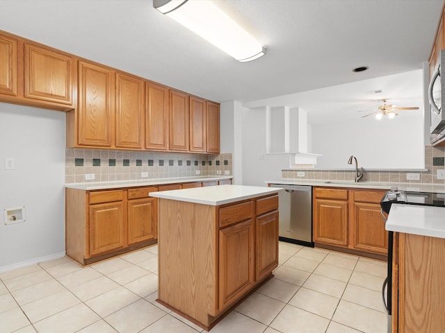 kitchen featuring tasteful backsplash, light tile patterned floors, a kitchen island, ceiling fan, and stainless steel appliances