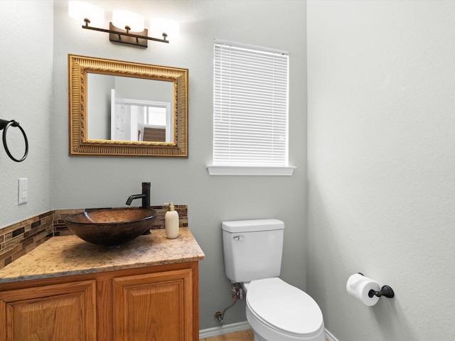 2425 Brycewood Ln, Plano, TX 75025 - half bathroom featuring toilet, backsplash, and vanity
