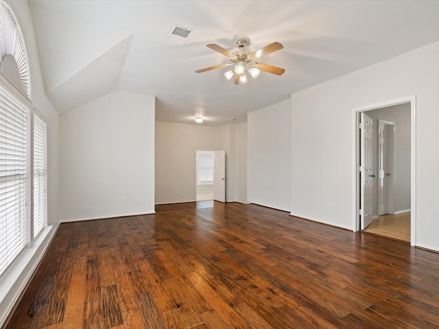 empty room with dark wood-type flooring, ceiling fan, and vaulted ceiling