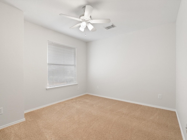 spare room with light colored carpet and ceiling fan