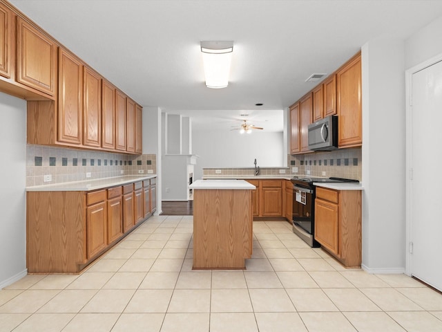 2425 Brycewood Ln, Plano, TX 75025 - kitchen with stainless steel microwave, electric range oven, decorative backsplash, light countertops, and ceiling fan