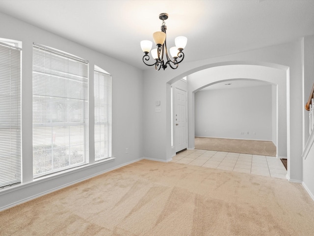 2425 Brycewood Ln, Plano, TX 75025 - carpeted empty room with arched walkways, a chandelier, tile patterned flooring, and baseboards