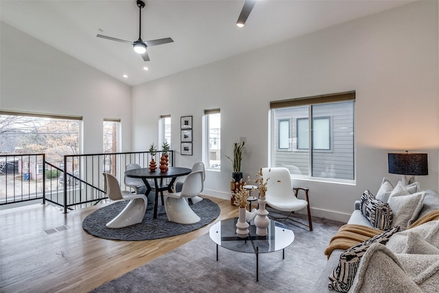 sitting room with visible vents, a ceiling fan, wood finished floors, high vaulted ceiling, and baseboards