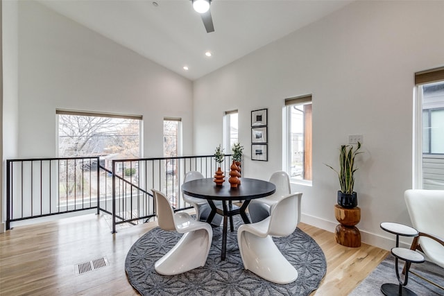 dining space featuring visible vents, baseboards, light wood-style flooring, high vaulted ceiling, and recessed lighting