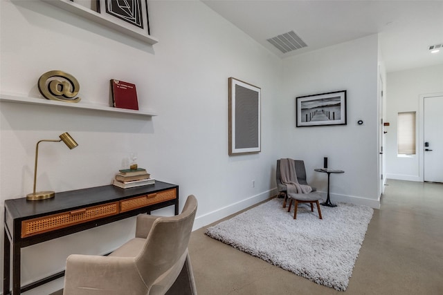 office space with finished concrete flooring, visible vents, and baseboards