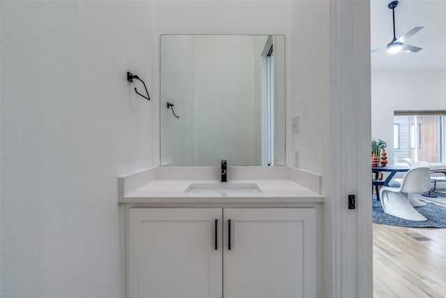 bathroom with ceiling fan, vanity, and wood finished floors