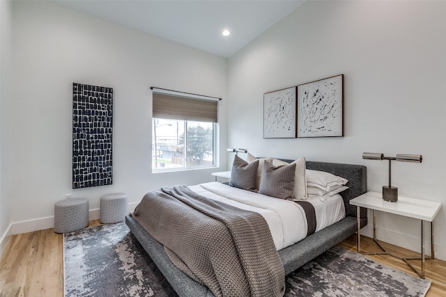 bedroom with baseboards, wood finished floors, and recessed lighting