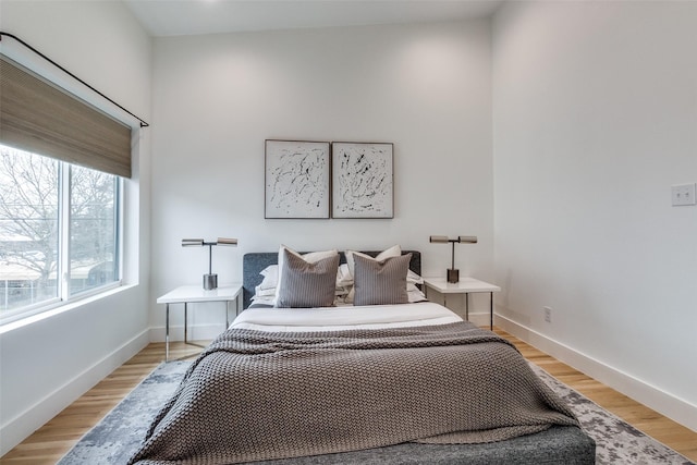 bedroom with light wood-type flooring and baseboards