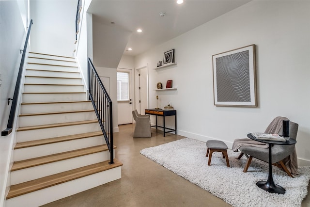 stairs featuring finished concrete flooring, baseboards, and recessed lighting