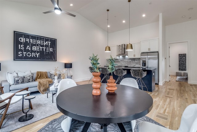 dining area featuring recessed lighting, light wood-style flooring, a ceiling fan, high vaulted ceiling, and baseboards