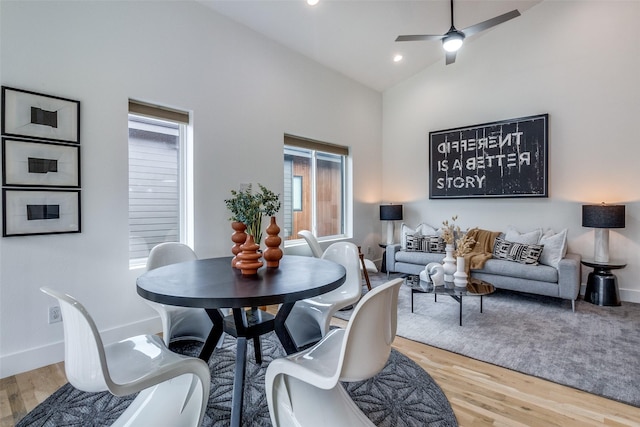 dining area featuring baseboards, a ceiling fan, light wood-style flooring, high vaulted ceiling, and recessed lighting