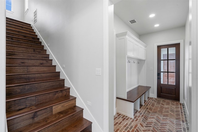 mudroom with brick floor, baseboards, visible vents, and recessed lighting