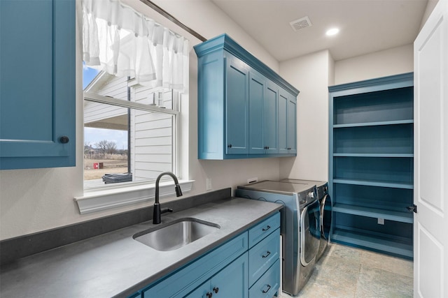 clothes washing area with a sink, visible vents, independent washer and dryer, and cabinet space