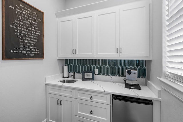kitchen with decorative backsplash, white cabinetry, fridge, and light stone countertops