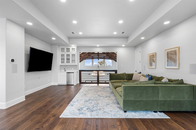 living room with dark wood finished floors, a tray ceiling, visible vents, recessed lighting, and baseboards