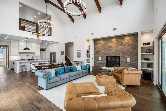living room featuring built in features, a chandelier, dark wood-style floors, stairs, and high vaulted ceiling