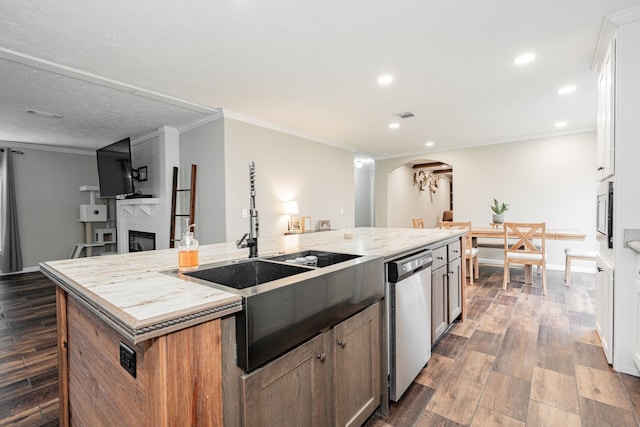 kitchen featuring appliances with stainless steel finishes, a fireplace, white cabinets, dark hardwood / wood-style flooring, and a large island