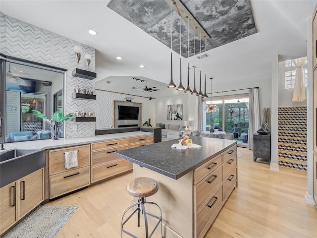 kitchen with open floor plan, light brown cabinetry, and light wood finished floors