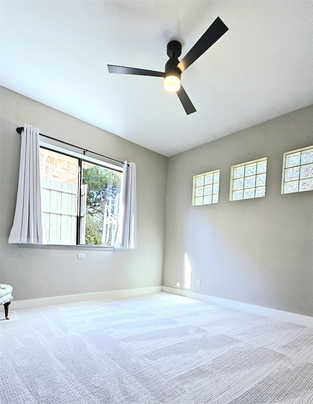 carpeted empty room with baseboards and ceiling fan