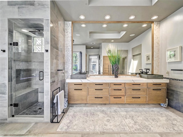 bathroom with vanity, a shower stall, recessed lighting, and tile walls