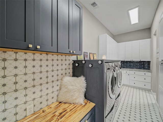 laundry room featuring cabinet space, visible vents, light floors, and washing machine and clothes dryer