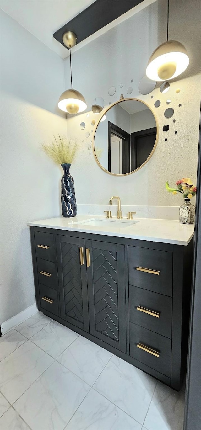 bathroom featuring marble finish floor, vanity, and baseboards