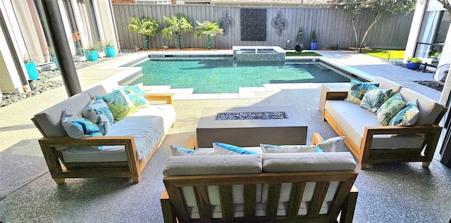 view of swimming pool with a pool with connected hot tub, a patio, an outdoor living space with a fire pit, and a fenced backyard