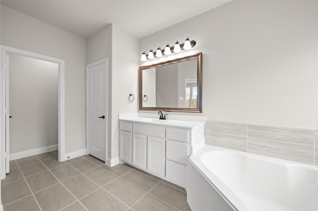 full bathroom with a bath, baseboards, vanity, and tile patterned flooring