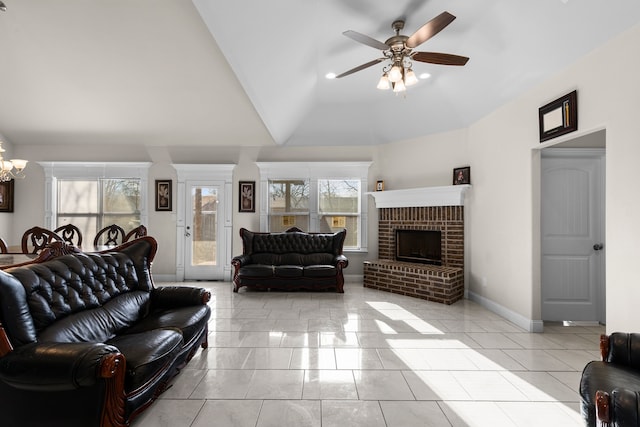 tiled living room with high vaulted ceiling, ceiling fan with notable chandelier, and a brick fireplace