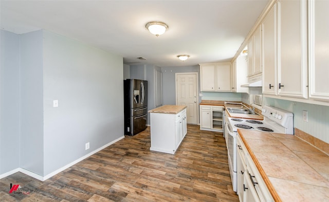 kitchen with dark wood-type flooring, white range with electric cooktop, stainless steel refrigerator with ice dispenser, a kitchen island, and tile countertops