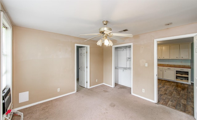 unfurnished bedroom featuring light carpet, a closet, and ceiling fan