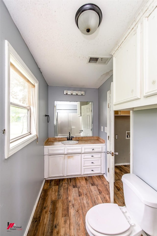 bathroom with vanity, hardwood / wood-style floors, a textured ceiling, and toilet